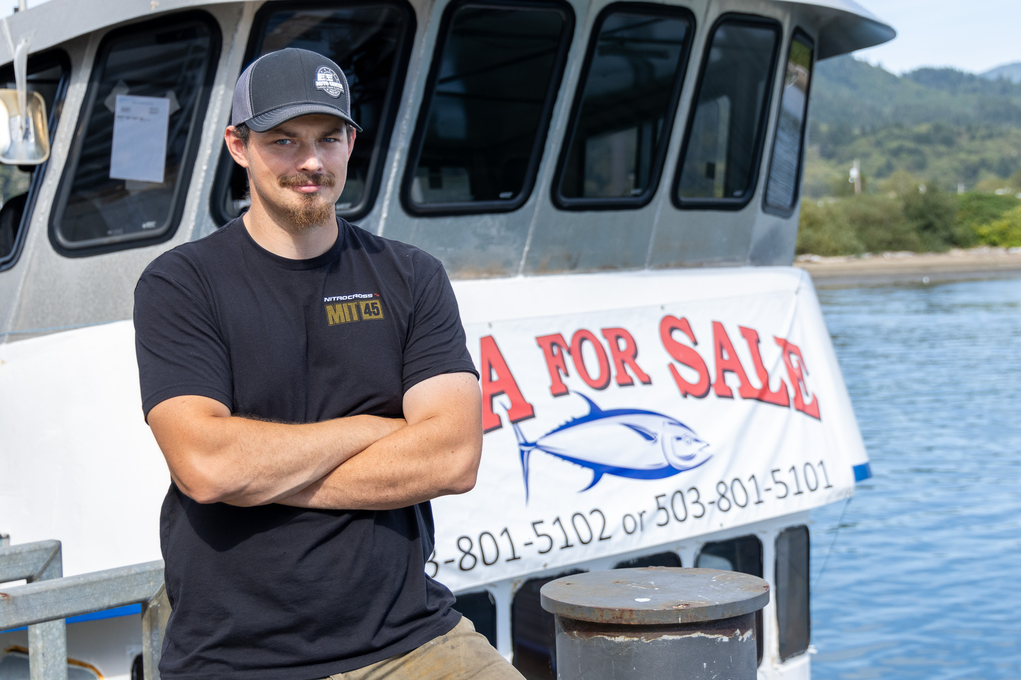 Fisherman standing in front of fishing boat
