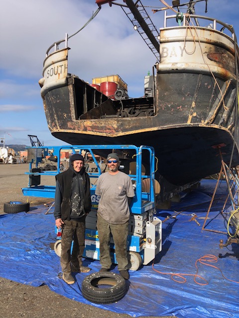 Rob Seitz and his son stand in front of their family boat.