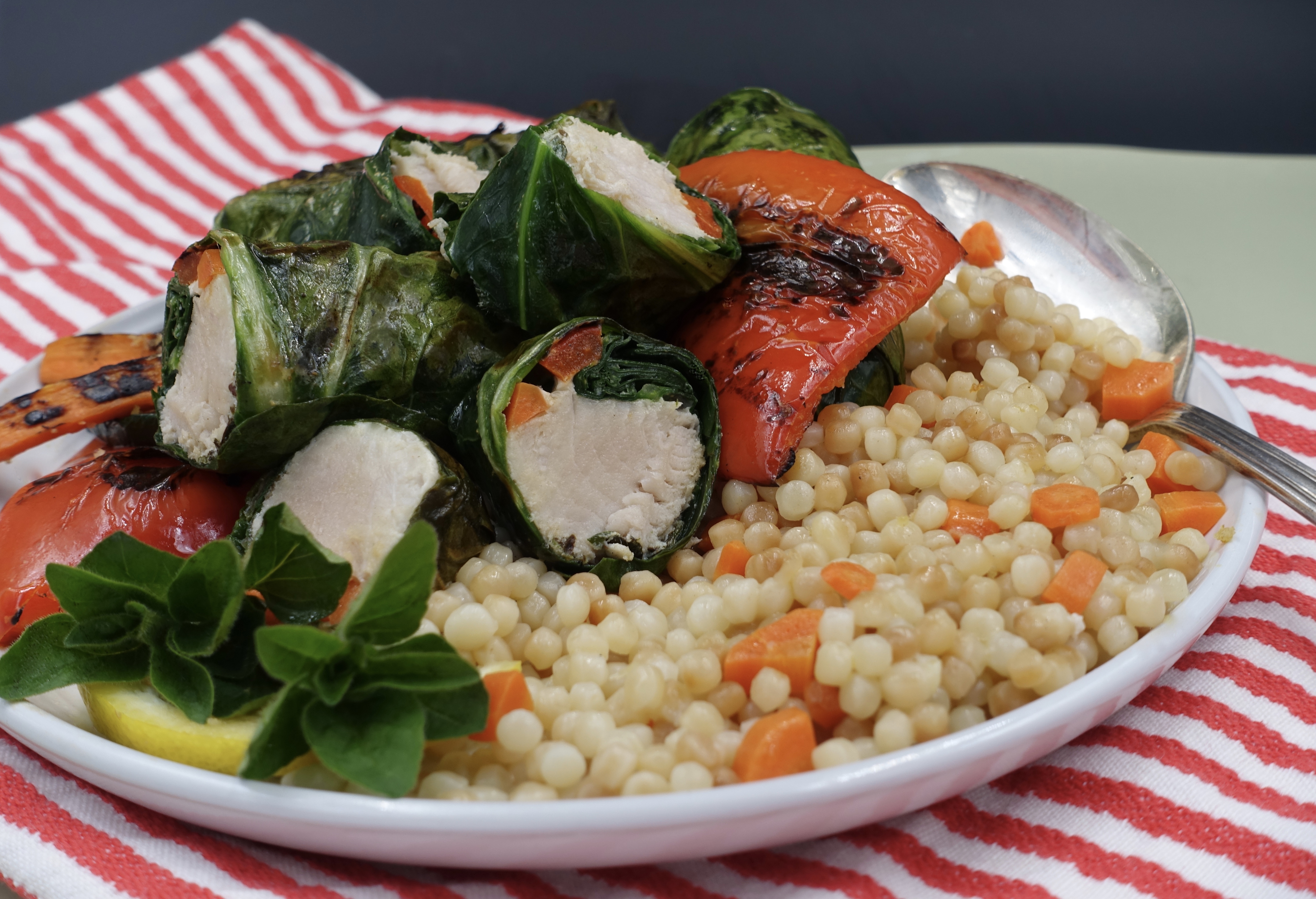 A plate of albacore tuna wrapped in swiss chard with cous cous.