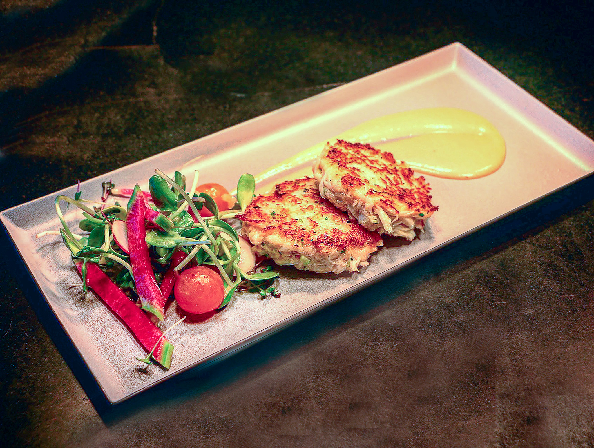 Meridian Dungeness crab cakes on a plate with sauce