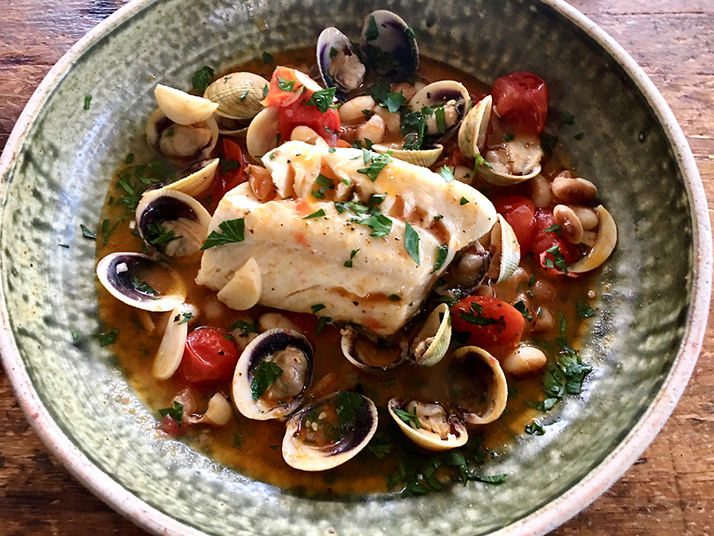 Plate of black cod with cockles and beans