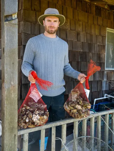 Whittaker holding bags of oysters 