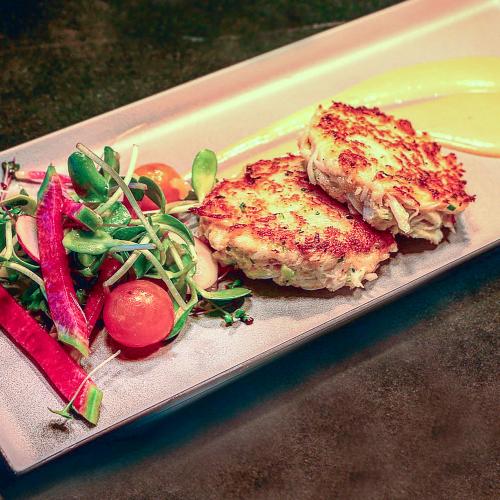 Meridian Dungeness crab cakes on a plate with sauce
